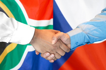 Handshake on South Africa and Czech Republic flag background.