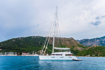 Fototapeta premium catamaran anchored in a bay mountains background Sea