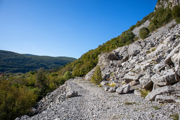 Fototapeta na wymiar Footpath next to the rocks and mountains and Una river in village Martin Brod in Bosnia and Herzegovina