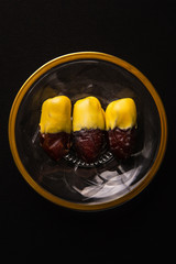 dates with saffron and yellow chocolate on crystal plate with golden design