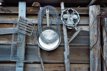 Old pieces of iron hanging on the wall of a rustic barn.