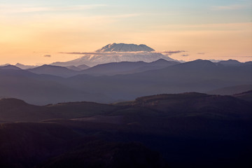 Mount St. Helens, active stratovolcano in Skamania County, Washington. Panoramic View from Sherrard Point, Fire Lookout at the top of Larch Mountain, Oregon. Sunset, Orange Sky, Mountain Silhouette