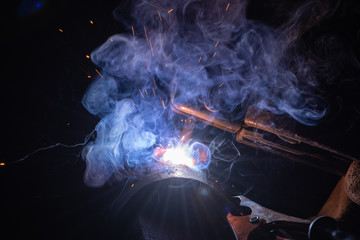 Blue smoke and red sparks while metal welding