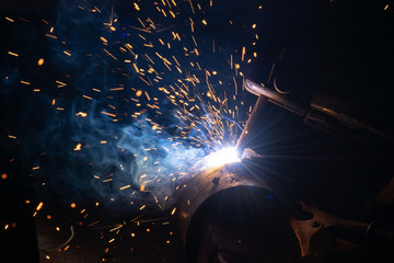 Closeup view of welding metal with smoke and hot sparks