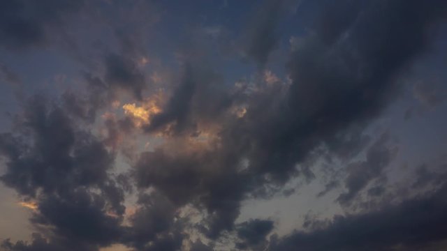 yellow dark sunset sky and clouds timelapse motion video of fast flying, passing, moving, rolling cloudscape, day to night bright colors nature background.