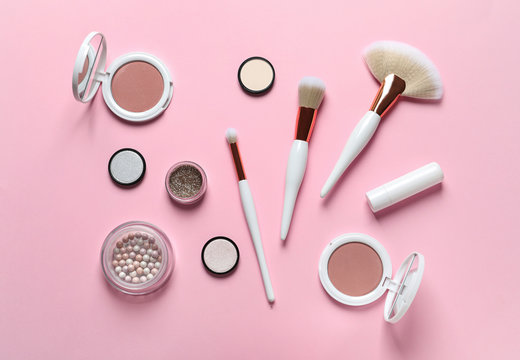 Flat lay composition with makeup brushes on pink background