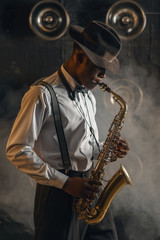 Plakat Black jazzman plays the saxophone on stage