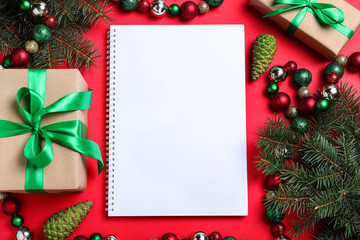 Fototapeta na wymiar Flat lay composition with empty notebook and Christmas decorations on red background, space for text. Writing letter to Santa Claus