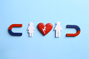 Magnets attracting couple on blue background, flat lay. Love concept