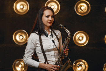 Female saxophonist plays the saxophone on stage