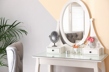Modern dressing table with flowers in stylish room interior