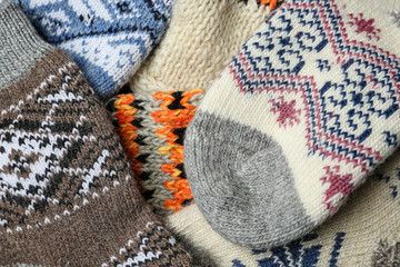 Different knitted woolen socks as background, closeup