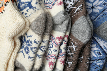 Fototapeta na wymiar Different knitted woolen socks as background, closeup