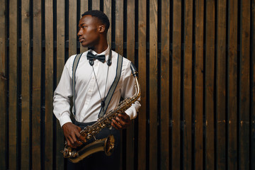 Jazz performer with saxophone, wooden background