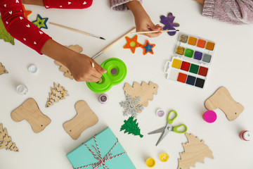Children making Christmas crafts at table, top view