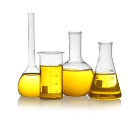 Laboratory glassware with yellow liquid on white background