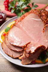 Delicious ham served with garnish on wooden table, closeup