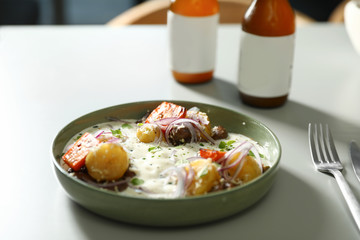 Beer and tasty dish served on light table, closeup