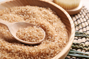 Salt for spa scrubbing procedure in wooden bowl on table, closeup