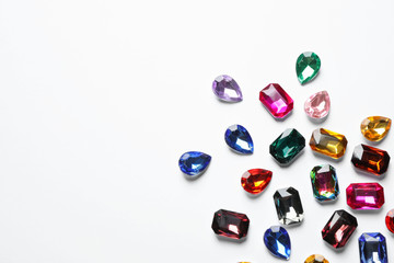 Different beautiful gemstones on white background, top view