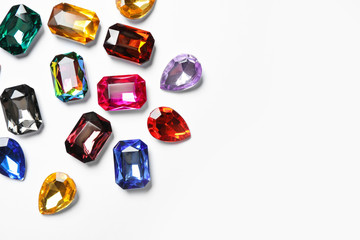 Different beautiful gemstones on white background, top view