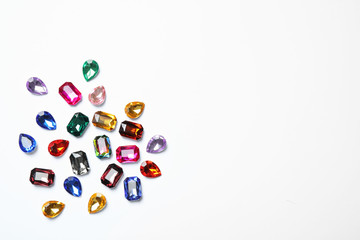 Different beautiful gemstones on white background, top view