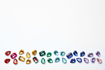 Different beautiful gemstones on white background, top view