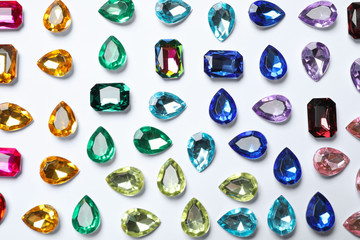 Different beautiful gemstones on white background, top view