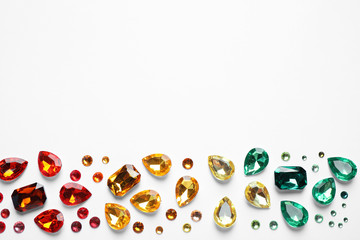 Different beautiful gemstones on white background, top view