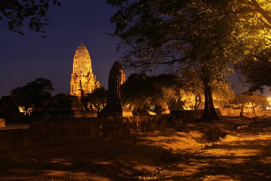 Temples at Ayuthaya in Thailand surrounded by trees at night time