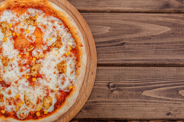Hawaiian pizza on dark rustic wooden background. Top view, copy space