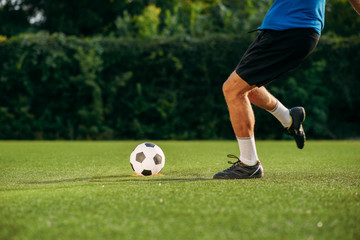 Male soccer player hits the ball on the field
