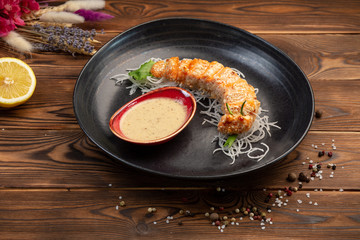 salmon slices baked in breadcrumbs on black round plate