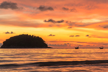 Fototapeta na wymiar stunning sunset in channel between islands. Koh Pu or crab island is in the middle between Kata beach and Karon beach.tourists playing blow plat in sunset at Kata beach