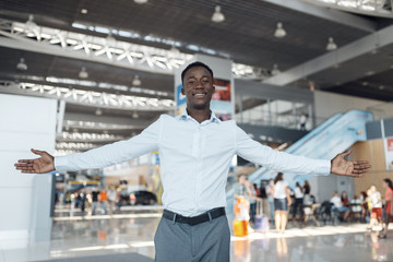 Negro businessman welcomes guests, car showroom