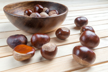 scattered in dish on wooden table top pile of fruit chestnuts