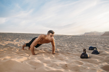 Sportsman doing push-up exercises in desert
