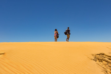 Fototapeta na wymiar A man and a woman at the desert horizon.
