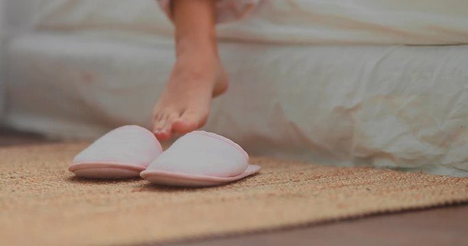 Slippers put on bare feet. Cozy house. Close-up.