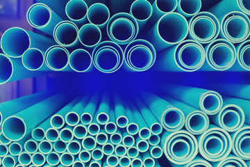 Close up to blue plastic pipe background, PVC pipes stacked in warehouse.