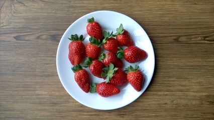 strawberries in a bowl on wooden table