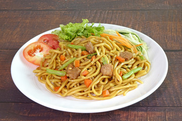 Noodles : stir fried noodle with tofu, carrots and green vegetables. Vegetarian food / Chinese food.