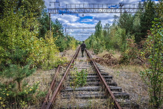 Man walks on railway tracks near Prypiat abandoned city, Ukraine