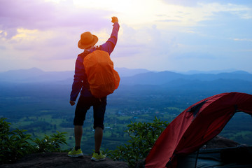 Backpacker,Tourists Raise your fist above your head enjoying the nature, the mountain with nature during sunset.tent