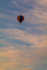 Rainbow hot-air balloon isolated in colorful clouds at sunrise, portrait