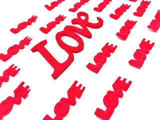 The letters are made of red, green sponge. The word love on a white background.