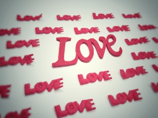 The letters are made of red, green sponge. The word love on a white background.