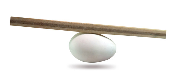 Balance concept, board on egg balance isolated on white background, balancing on seesaw in...