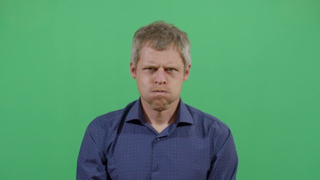 Adult Man Inflating The Cheeks. Studio Isolated Shot Against Green Screen Background