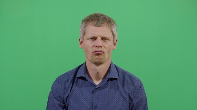 Facial Expression Of A Adult Man Pouting. Studio Isolated Shot Against Green Screen Background